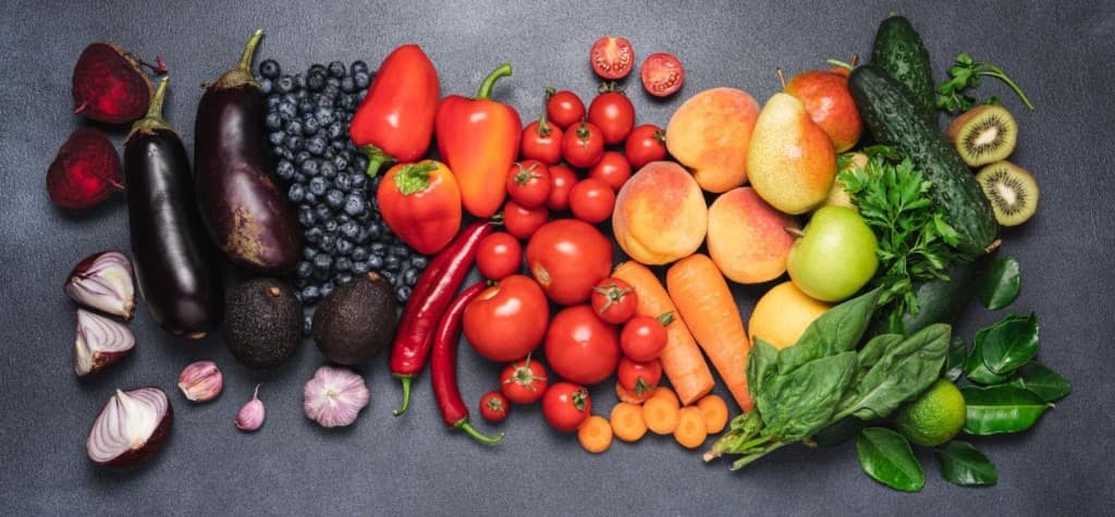 Colourful fruits and vegetables arranged in a rainbow pattern